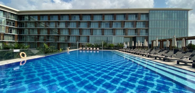 a pool with chairs and a building in the background