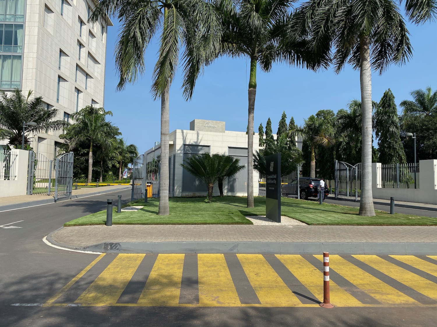 a building with palm trees and a zebra crossing