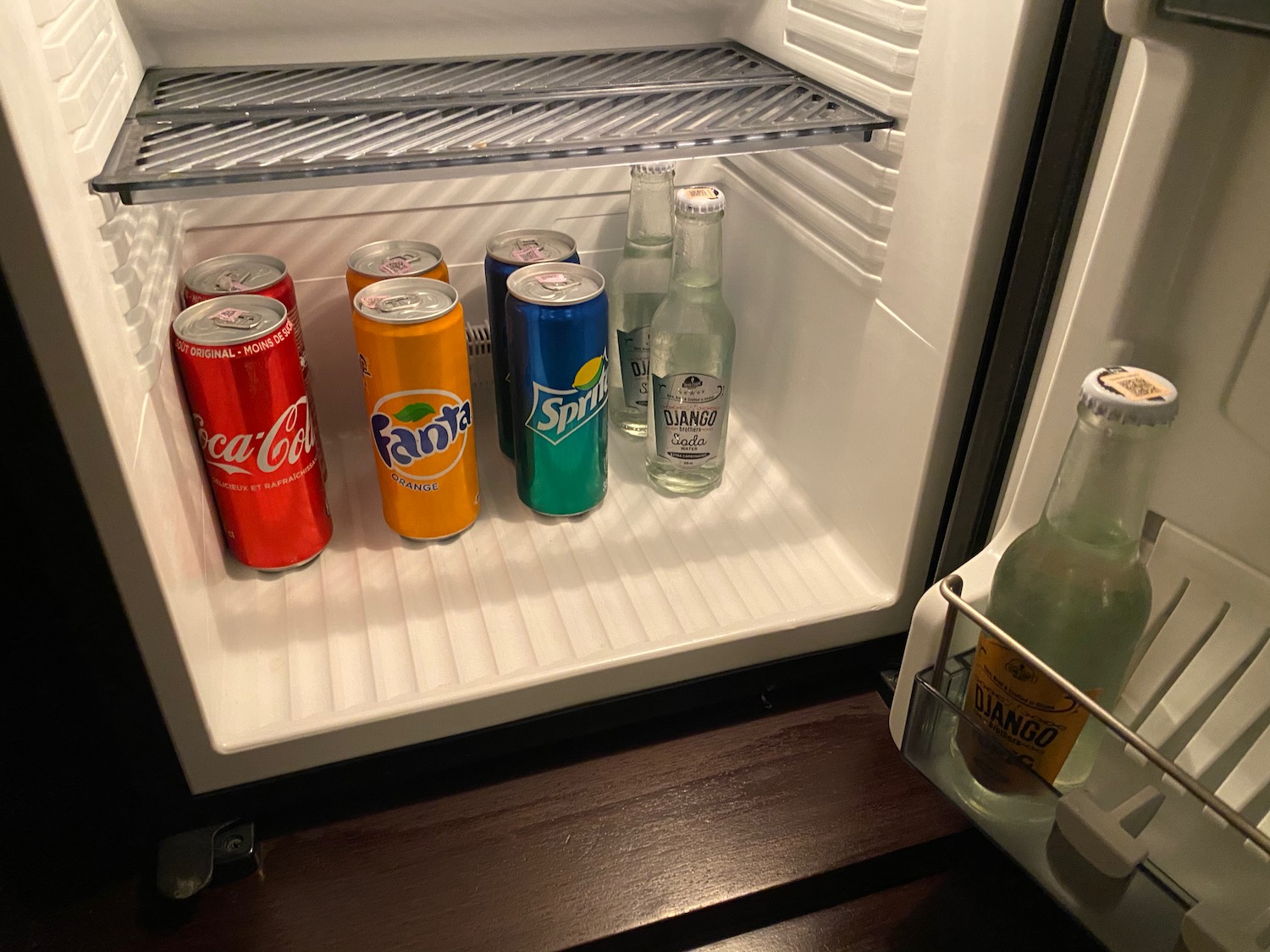 a refrigerator with soda cans and bottles