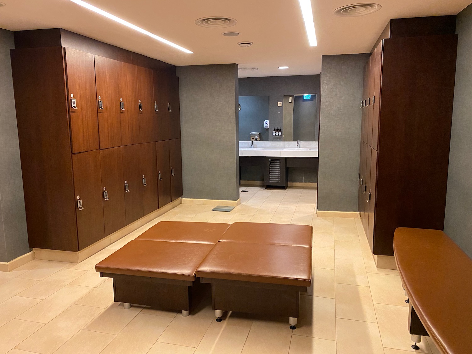 a locker room with brown benches and lockers