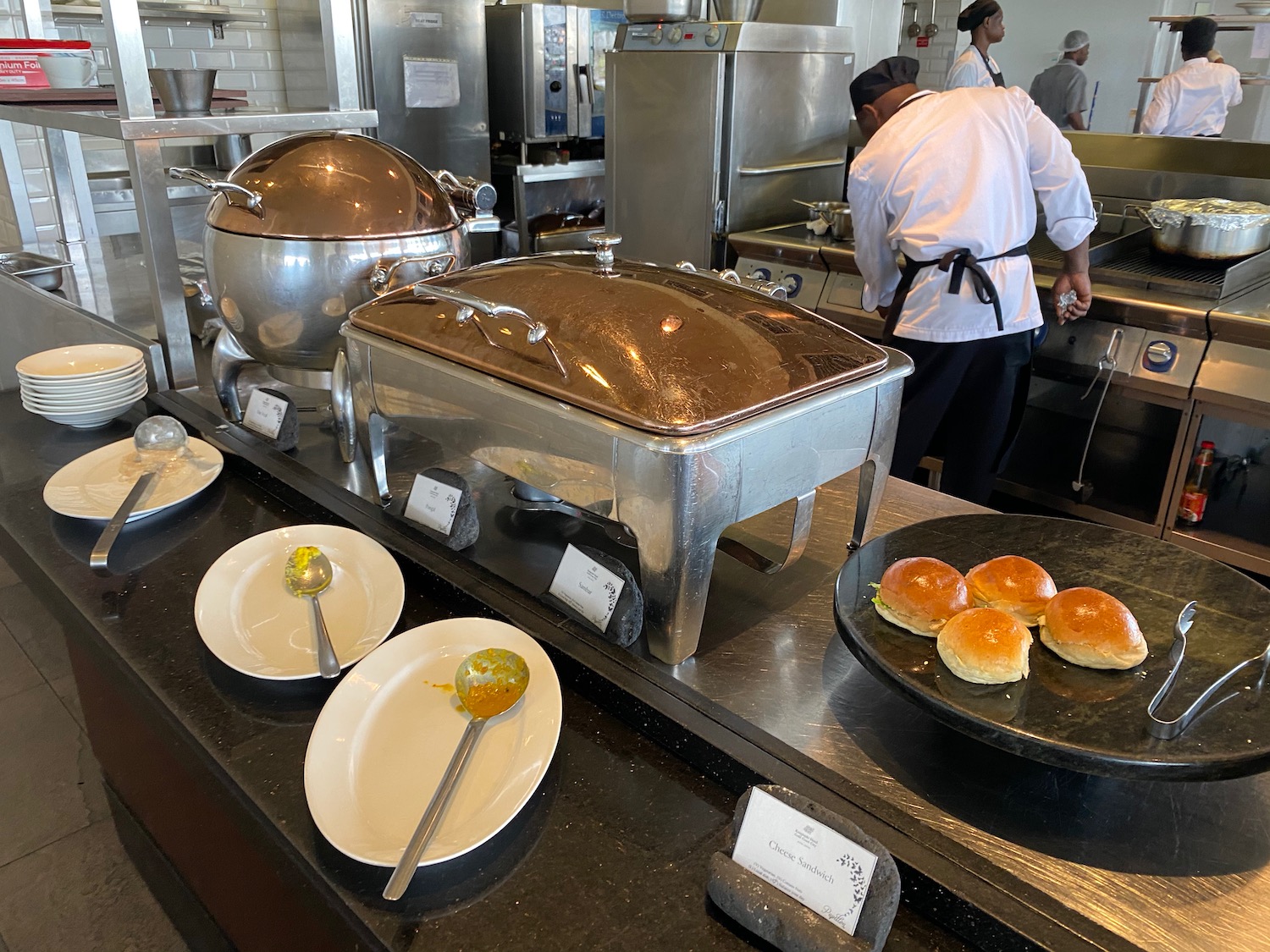 a kitchen with food on plates and a chef in the background