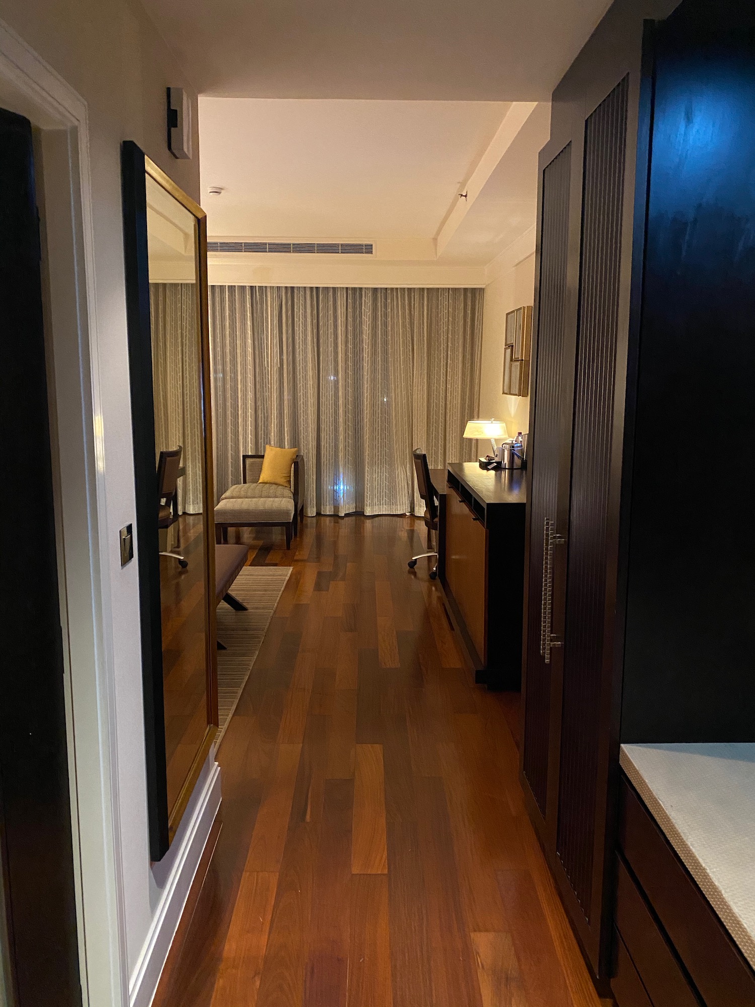 a hallway with a wood floor and a mirror
