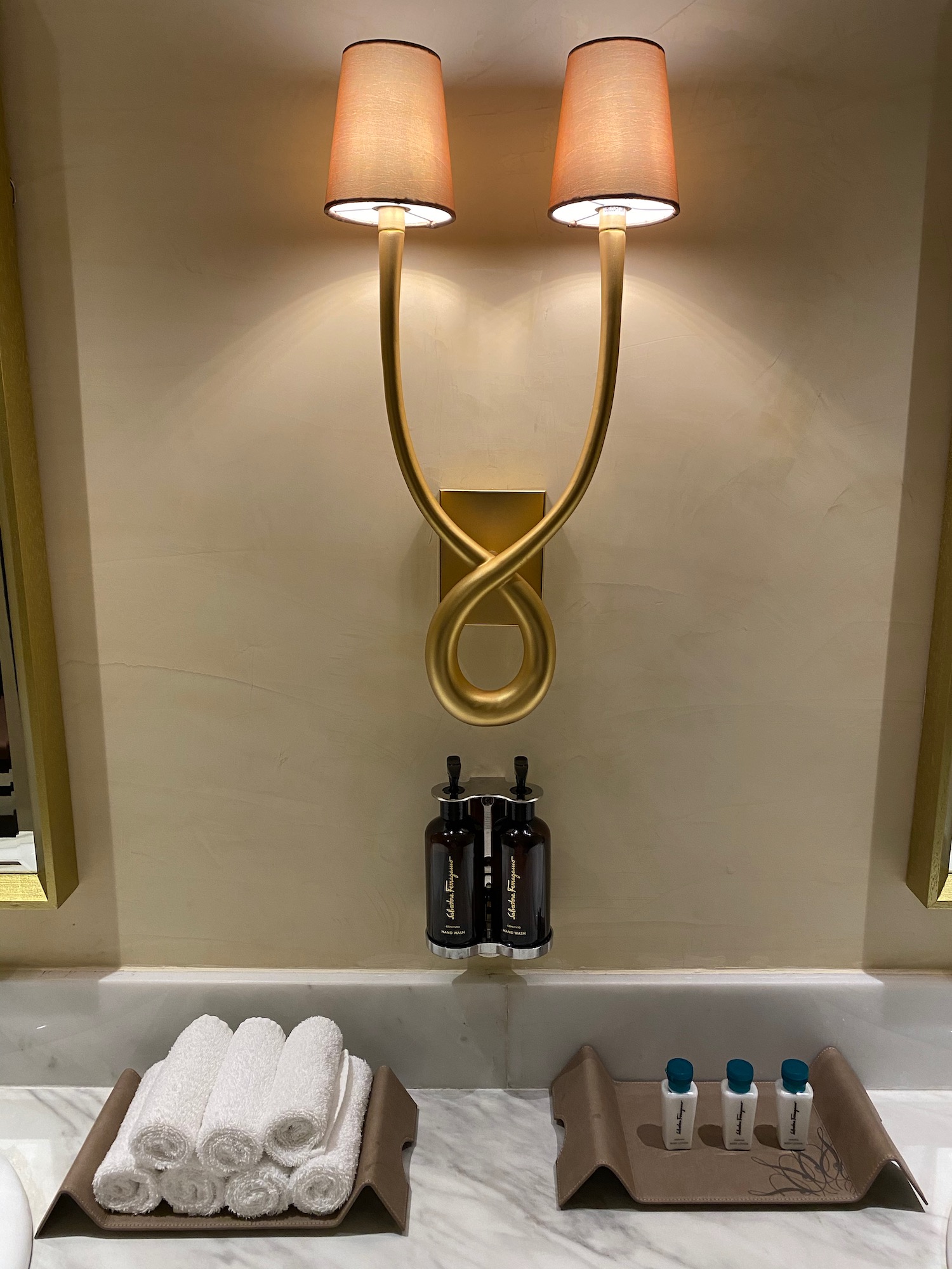 a bathroom with two lights and bottles of shampoo