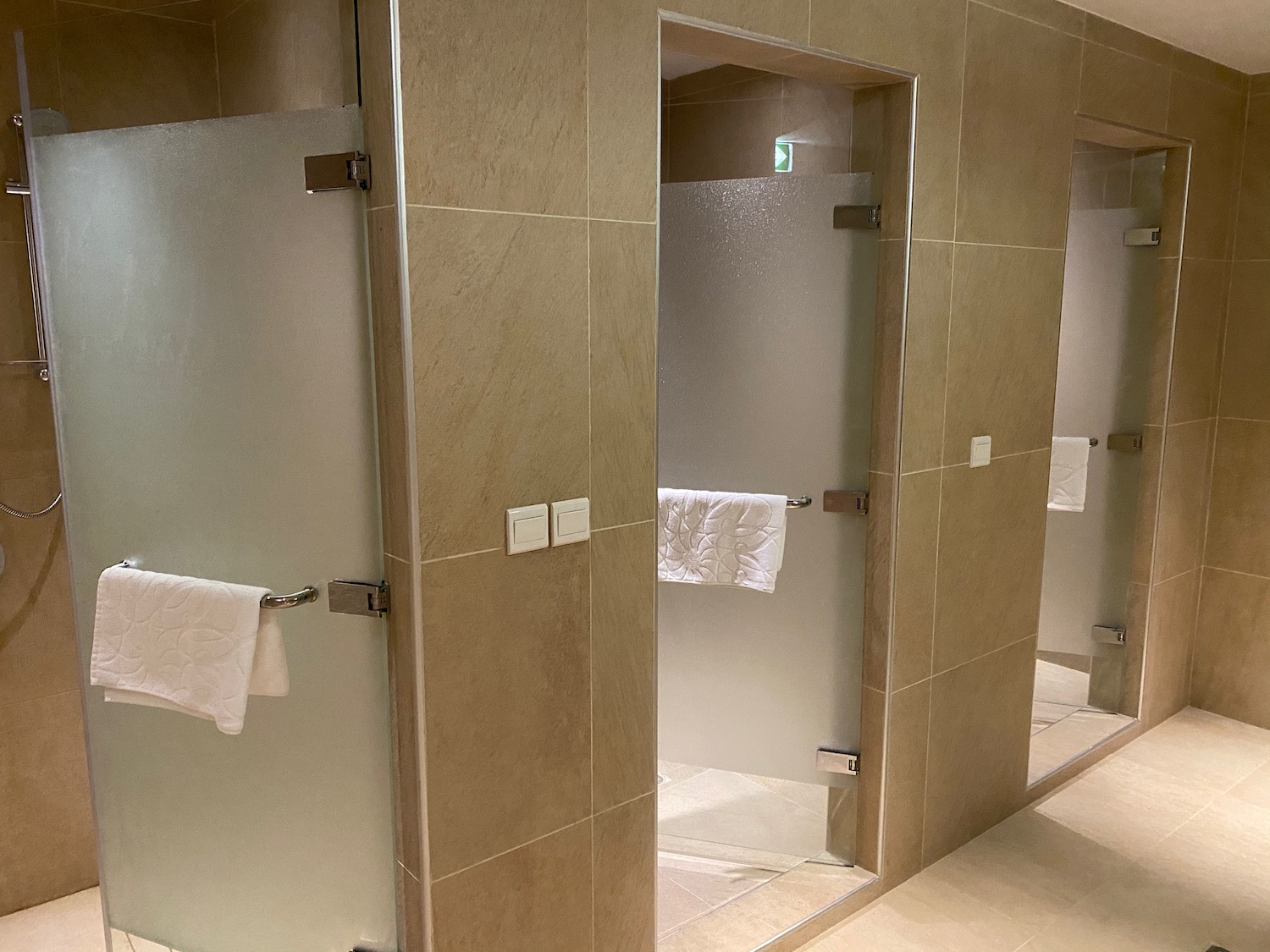 a bathroom with glass doors and towels