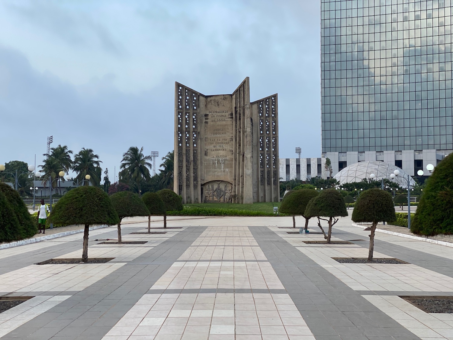 a stone structure with a monument in the middle of a park