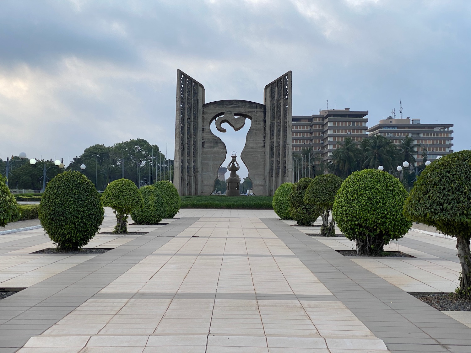 a stone structure with a statue in the middle of a park