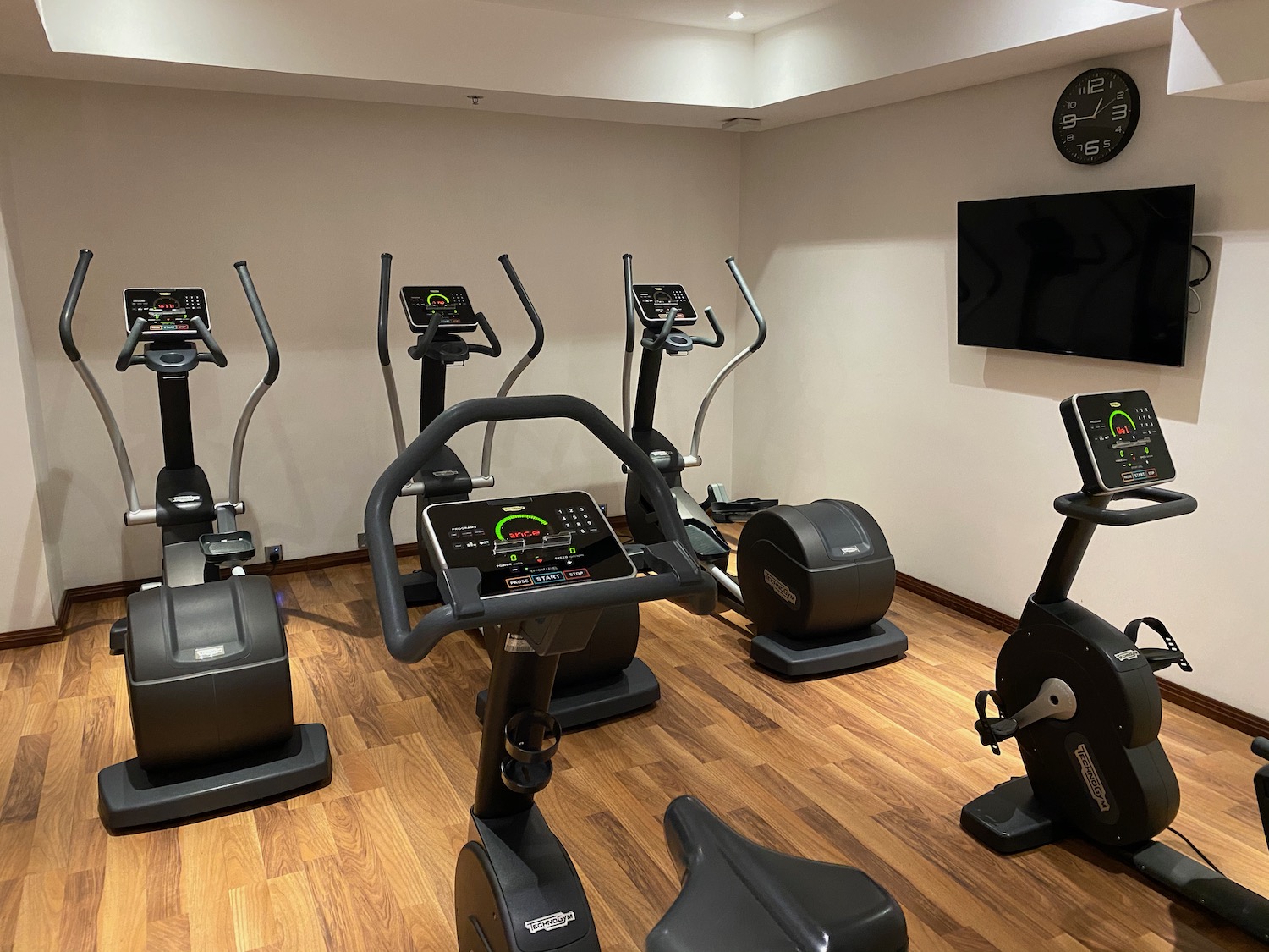 a room with exercise bikes and a wall clock