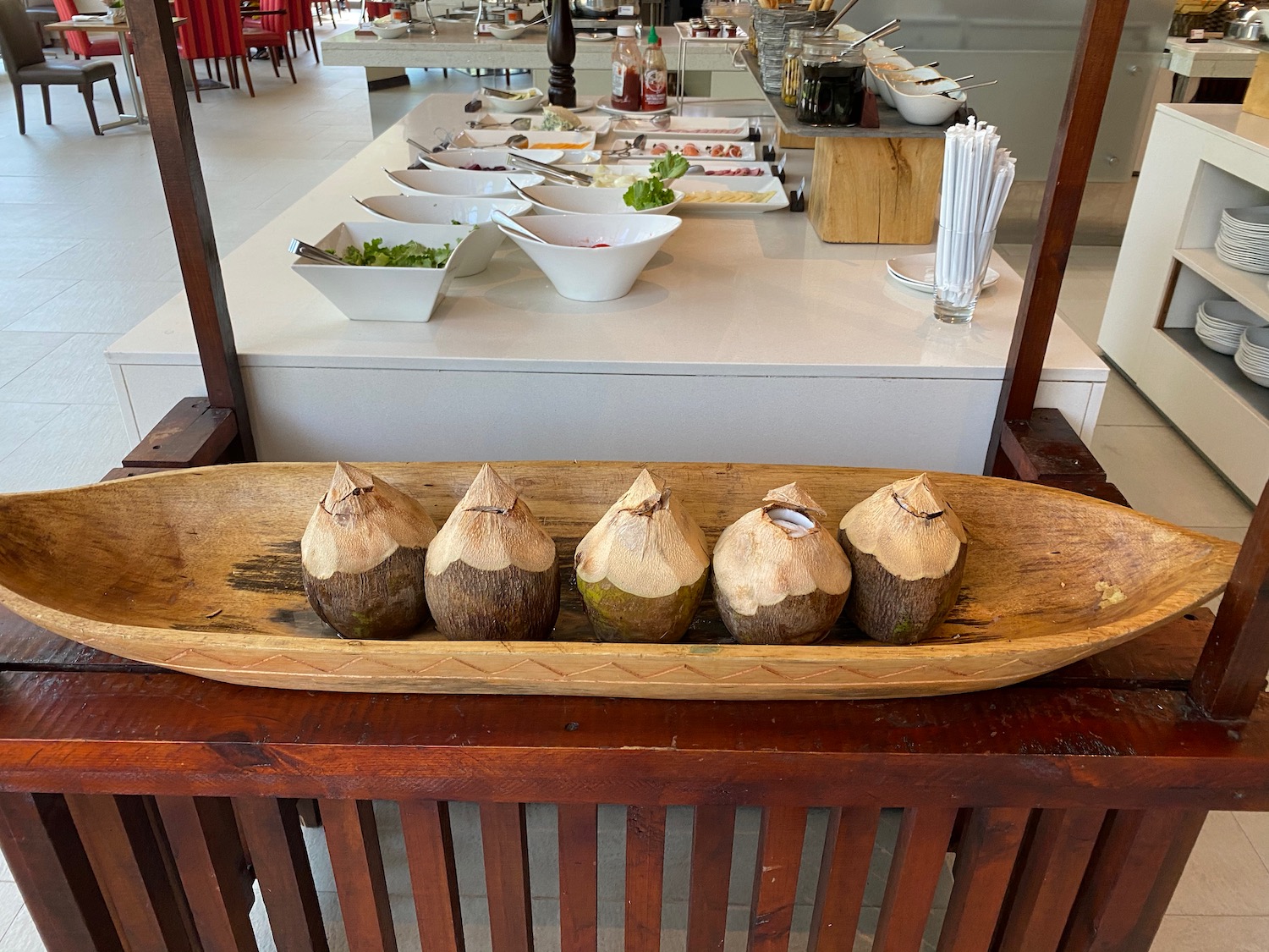 a row of coconuts on a wooden tray