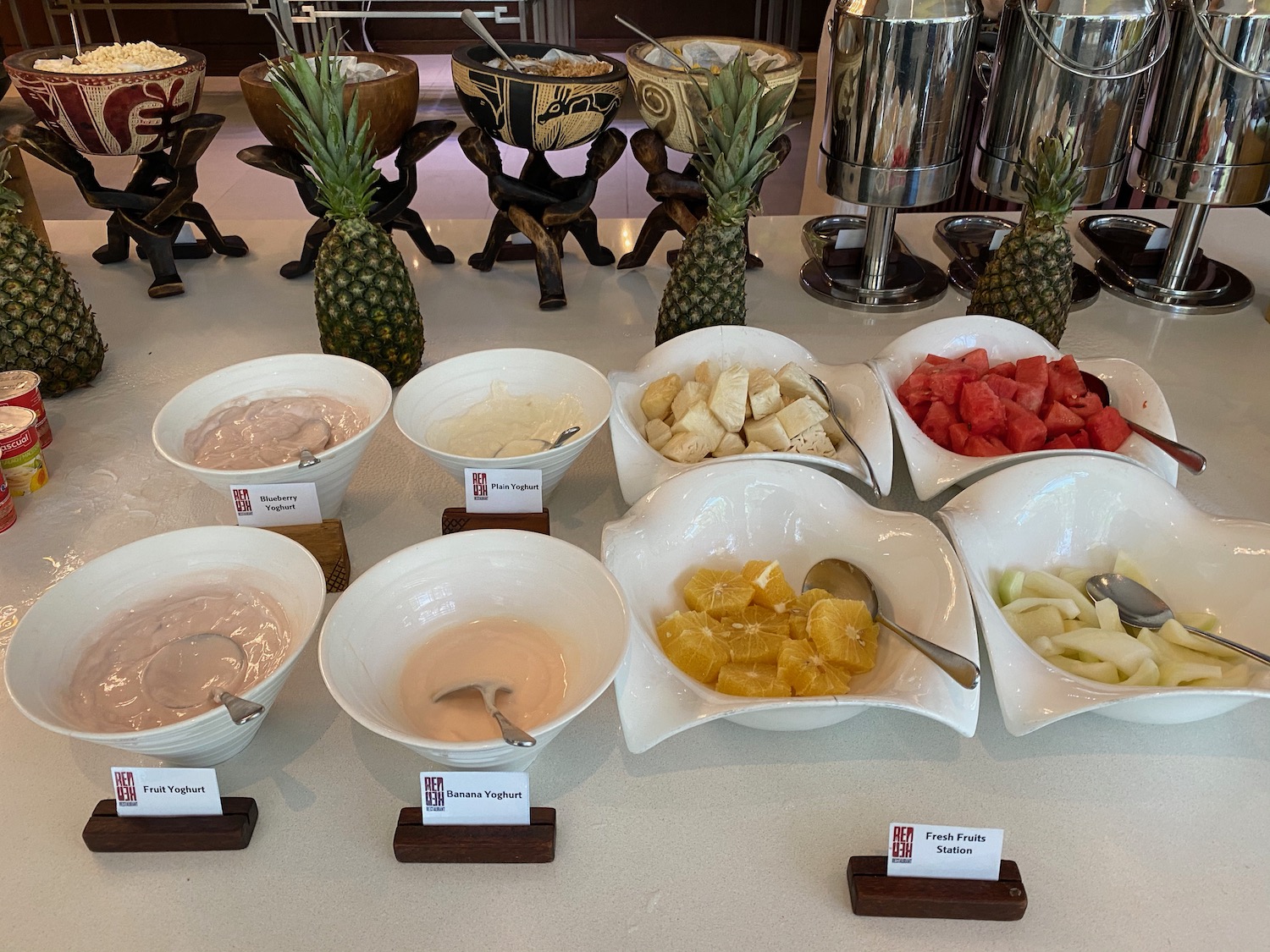 a table with bowls of fruit and yogurt