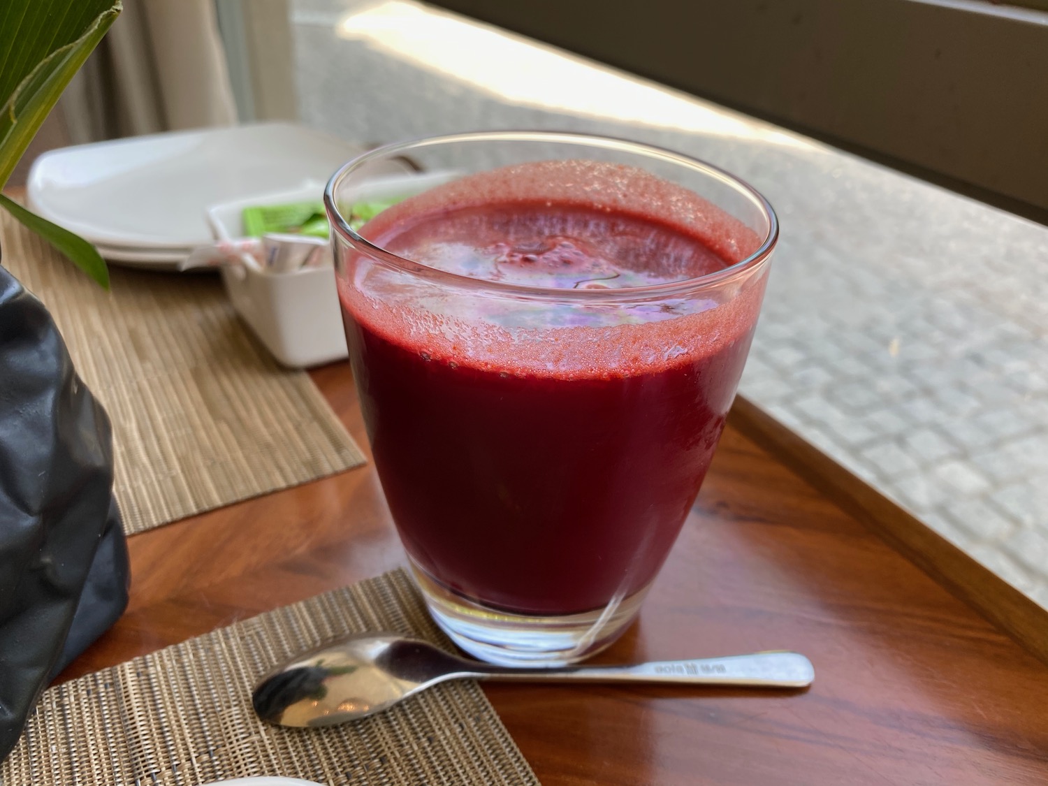 a glass of red liquid on a table