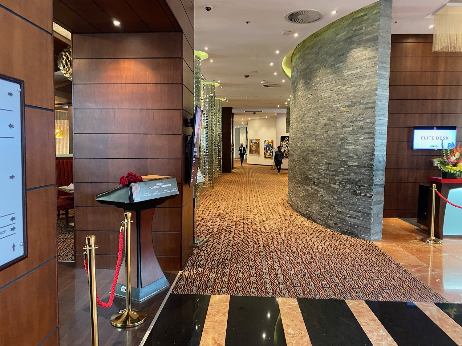 a hallway with a stone wall and a podium