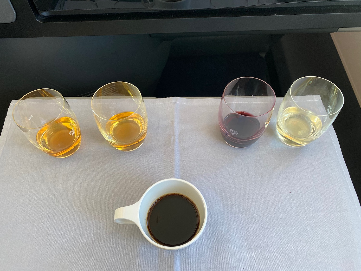 a group of glasses of liquid and a cup of coffee