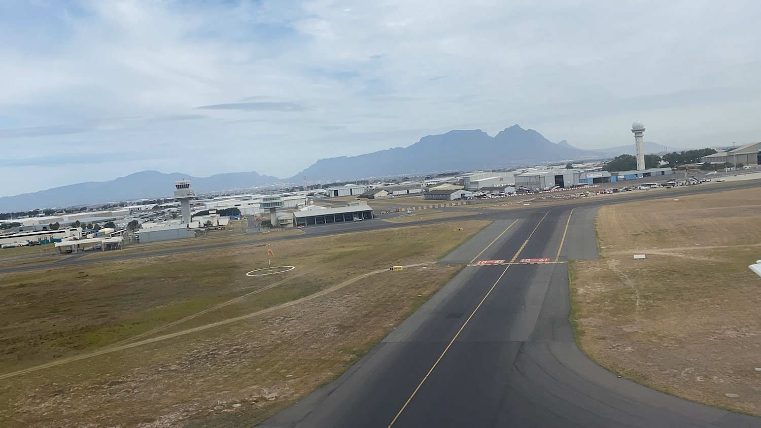 an airport runway with buildings in the background