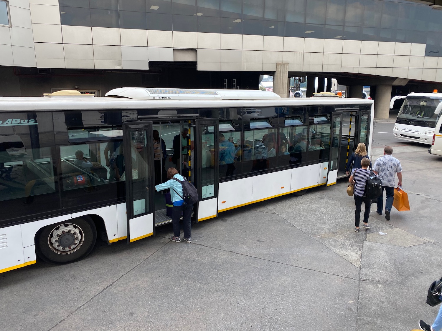 a group of people standing next to a bus