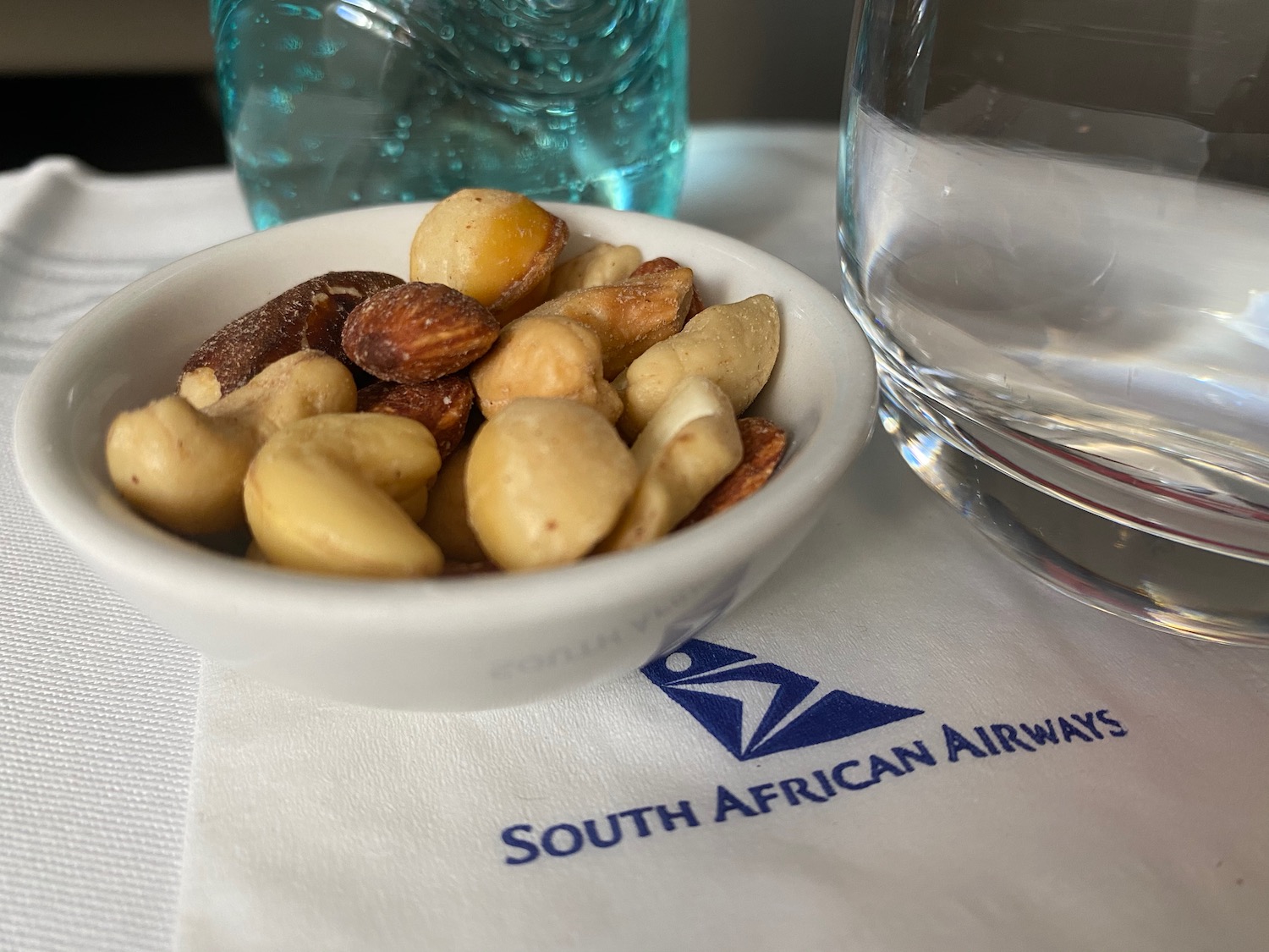 a bowl of nuts and a glass of water