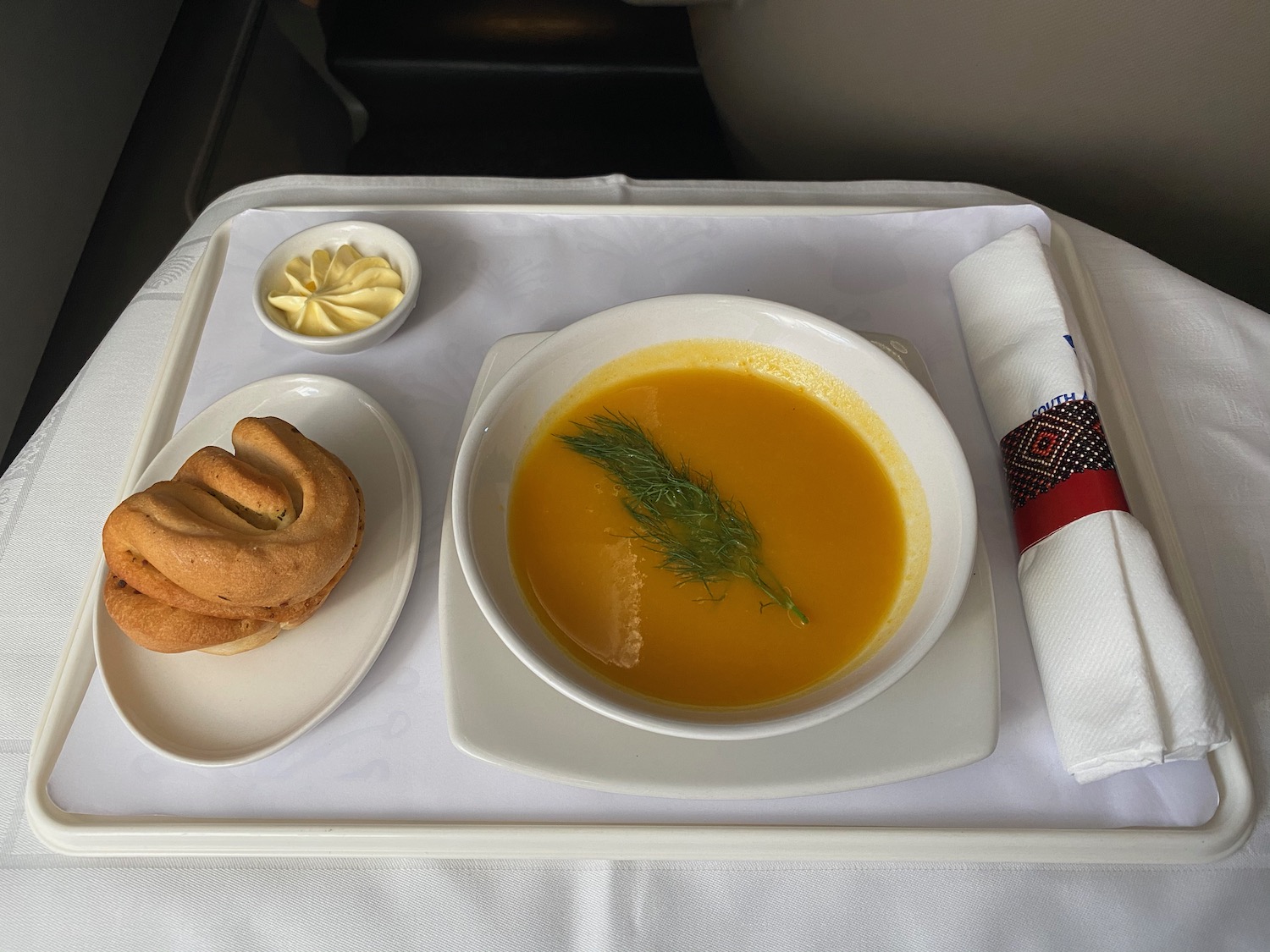 a plate of soup and a cookie on a tray