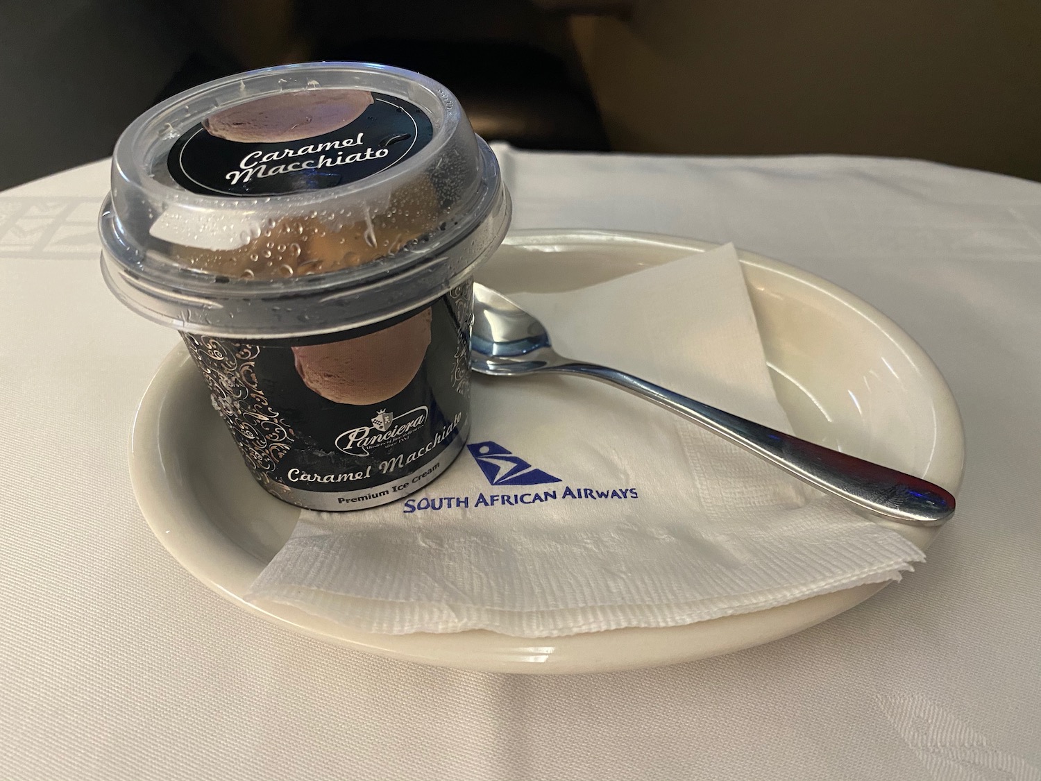 a cup of ice cream on a plate with a spoon