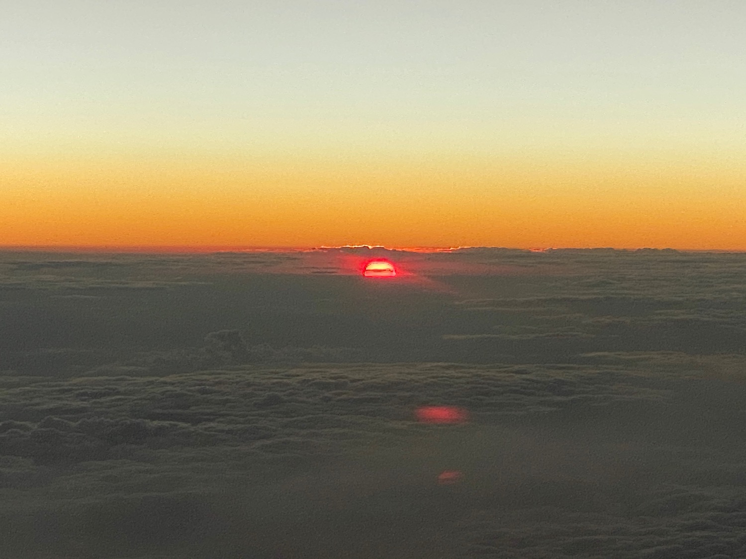 a sunset over clouds and a blue sky