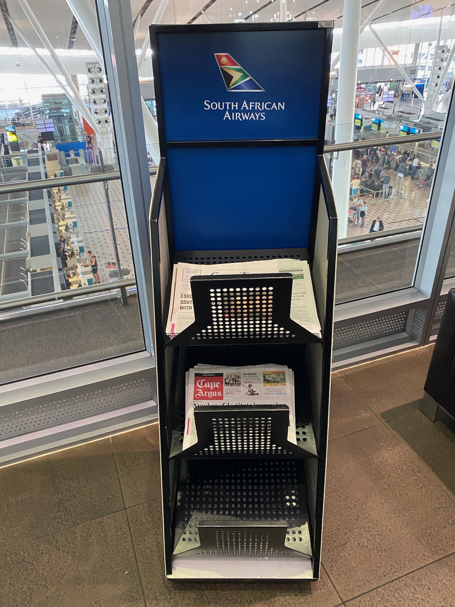 a blue and black display stand with newspaper on shelves