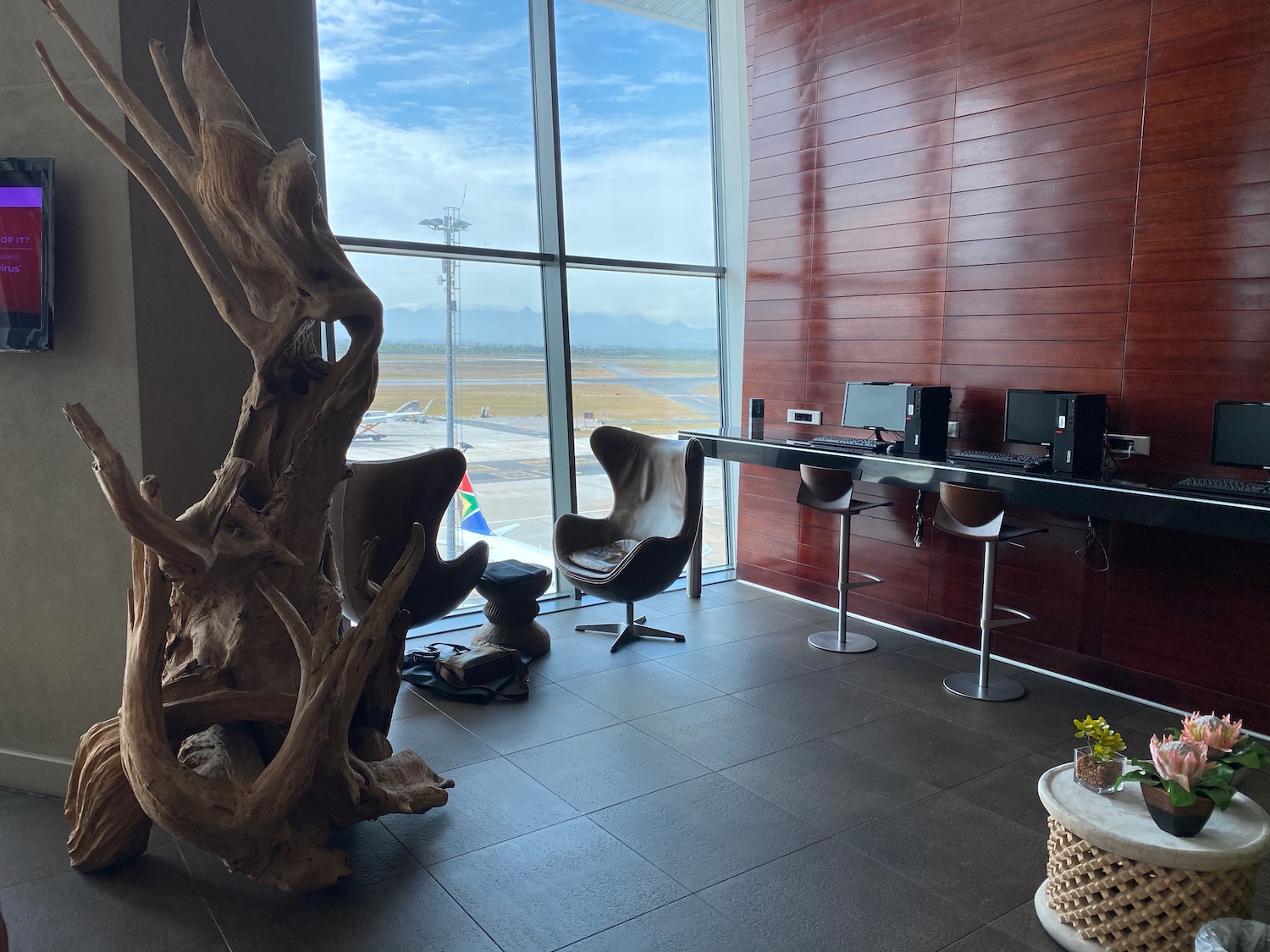 a room with a desk and chairs and a tree stump