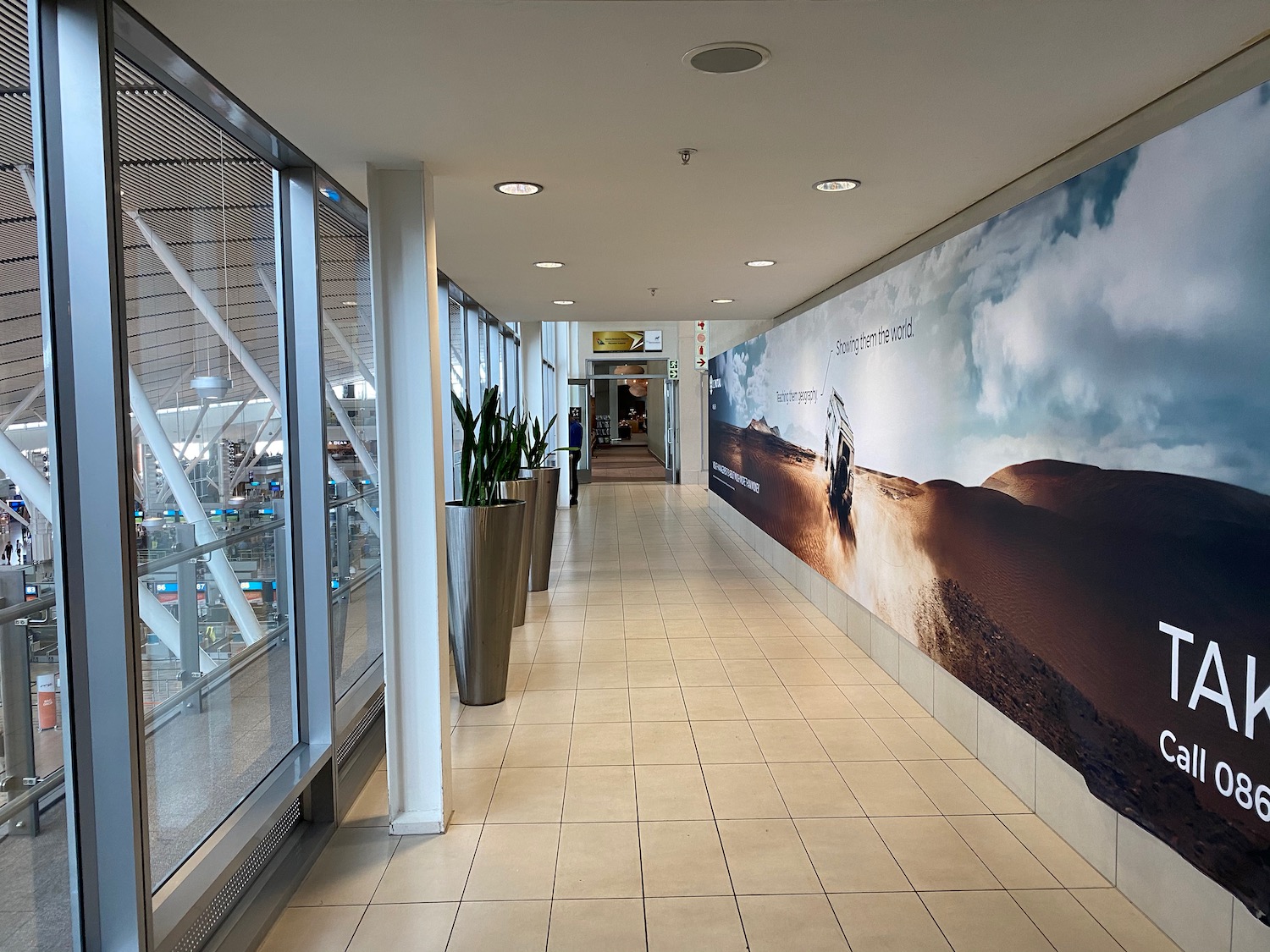 a hallway with large windows and a poster on the wall