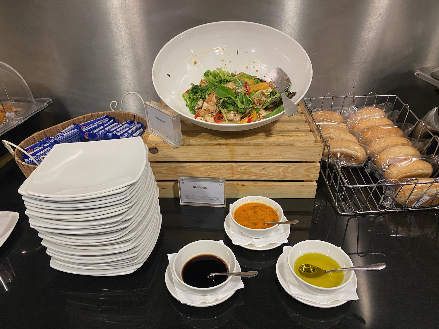 a bowl of salad and plates on a table