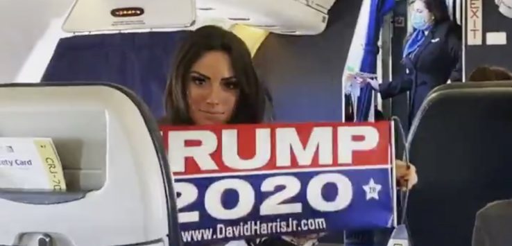 a woman holding a sign in a plane