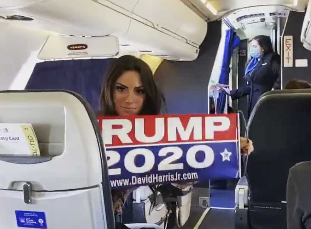 a woman holding a sign in a plane
