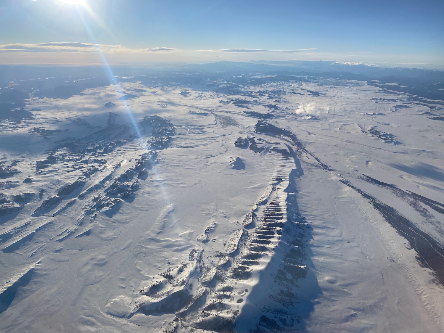 a snow covered landscape with mountains and blue sky