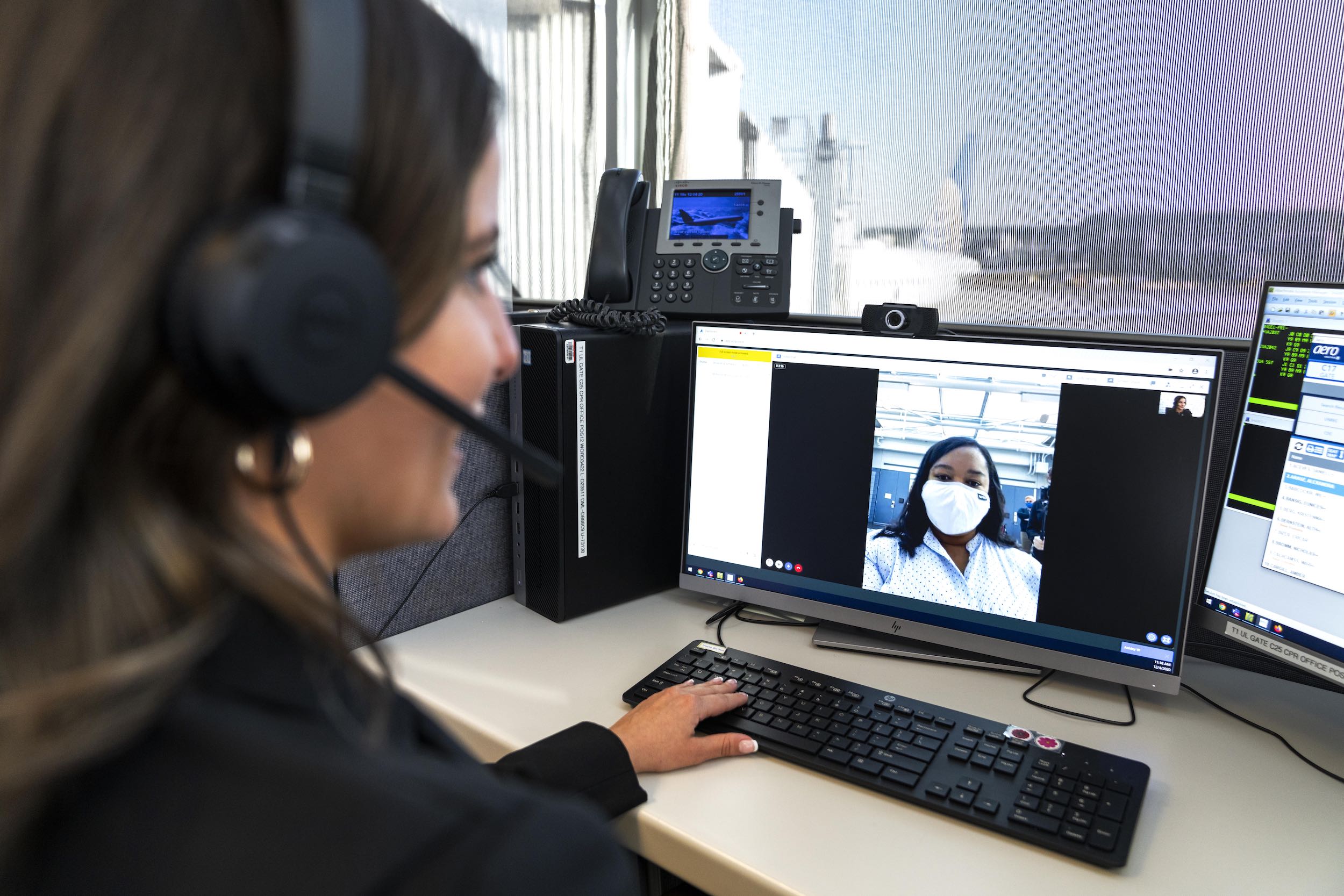 a woman wearing headset and a headset looking at a computer screen