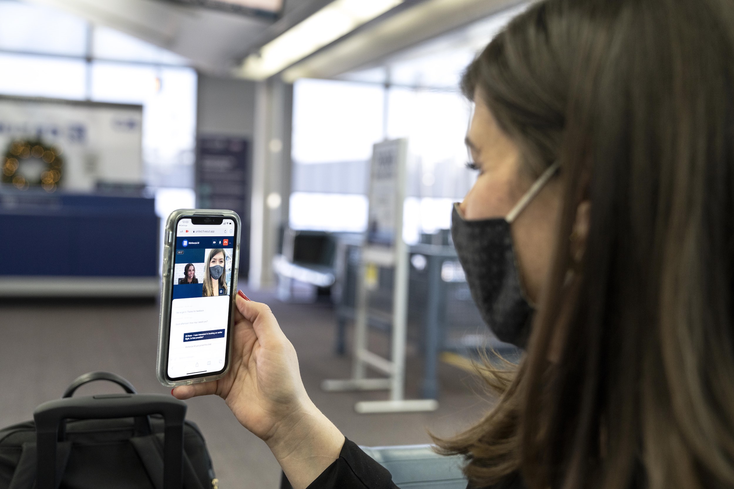 a woman wearing a mask and holding a phone