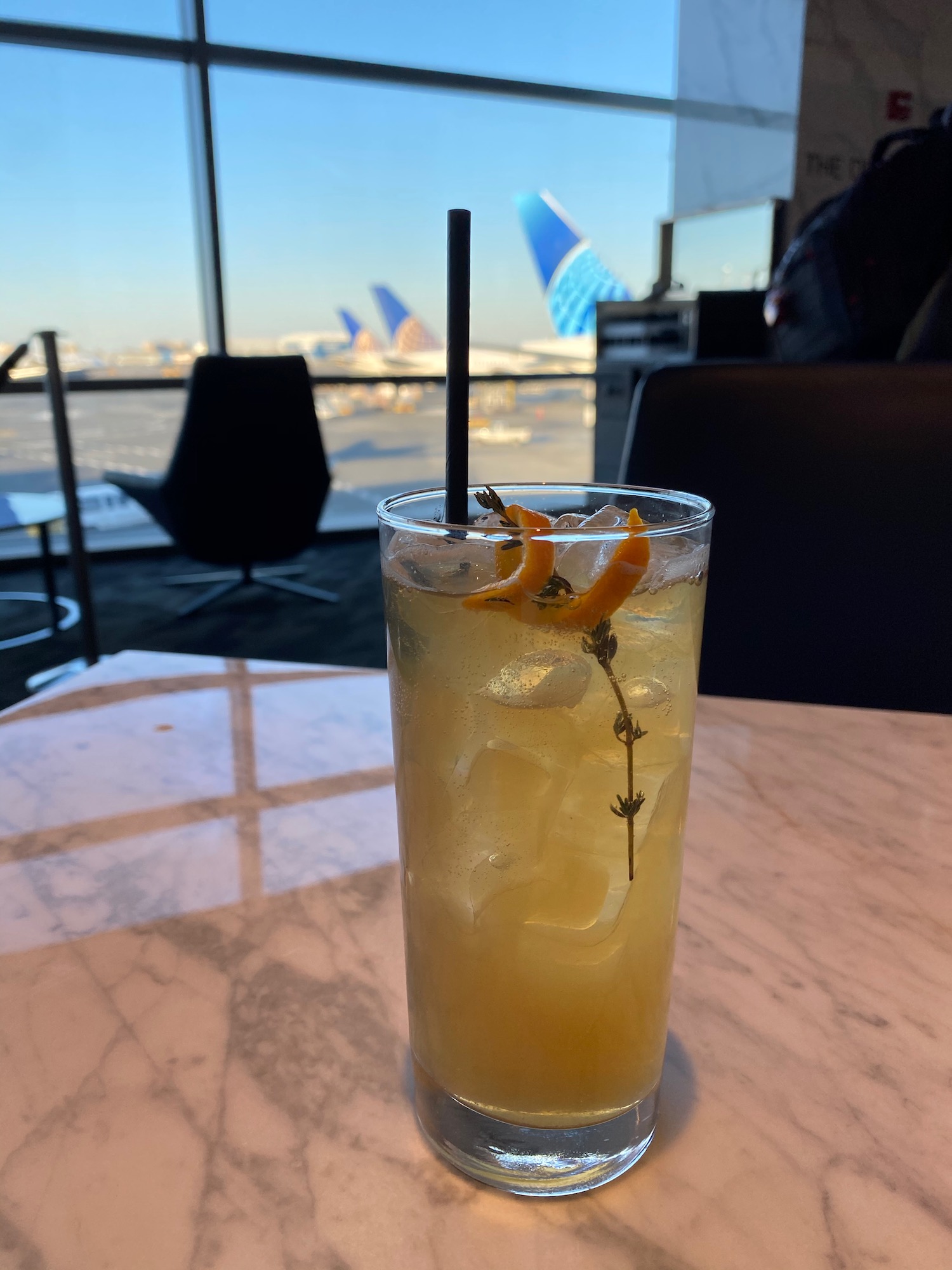 a glass of liquid with ice and oranges