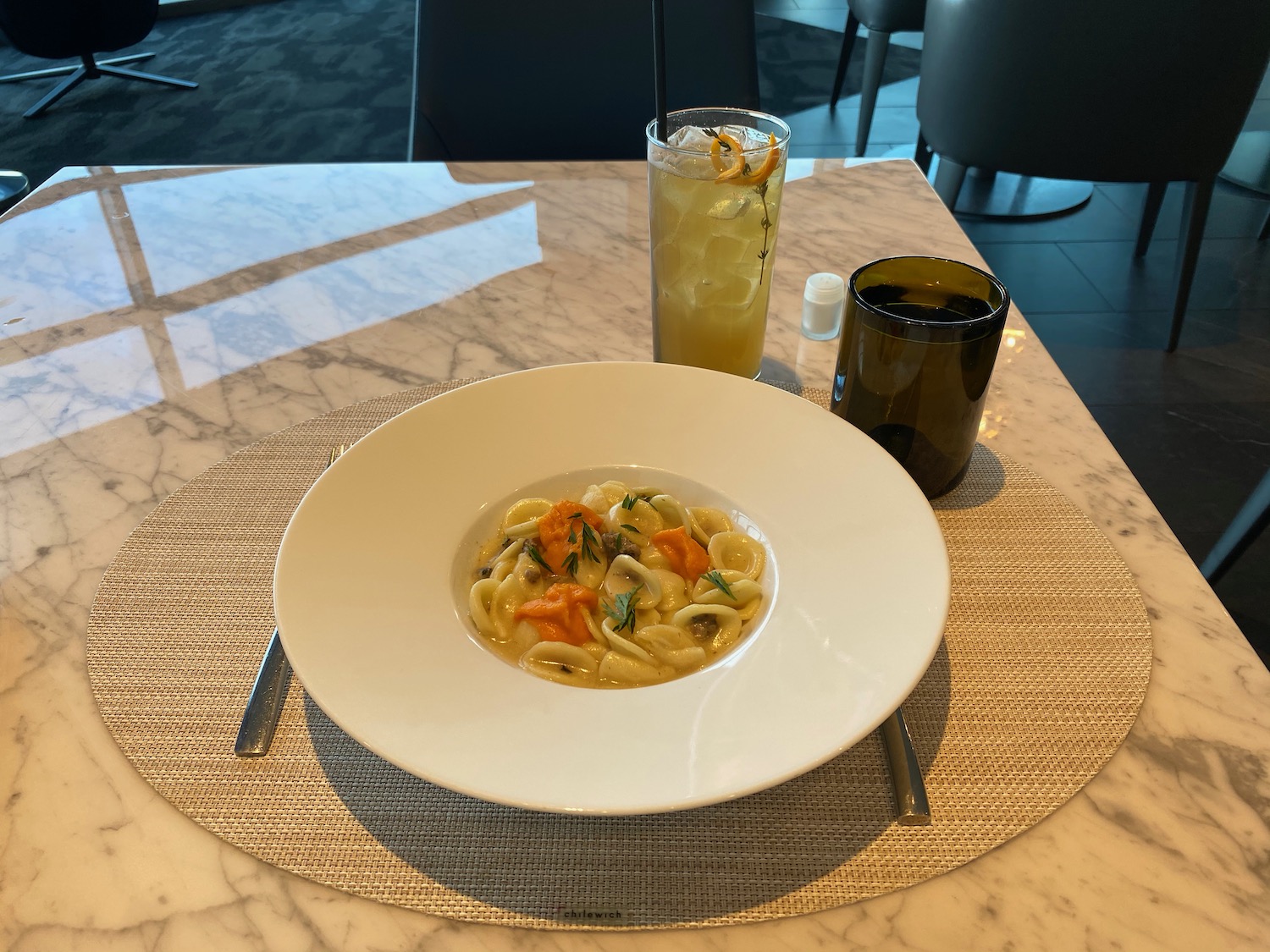 a plate of pasta and a drink on a table