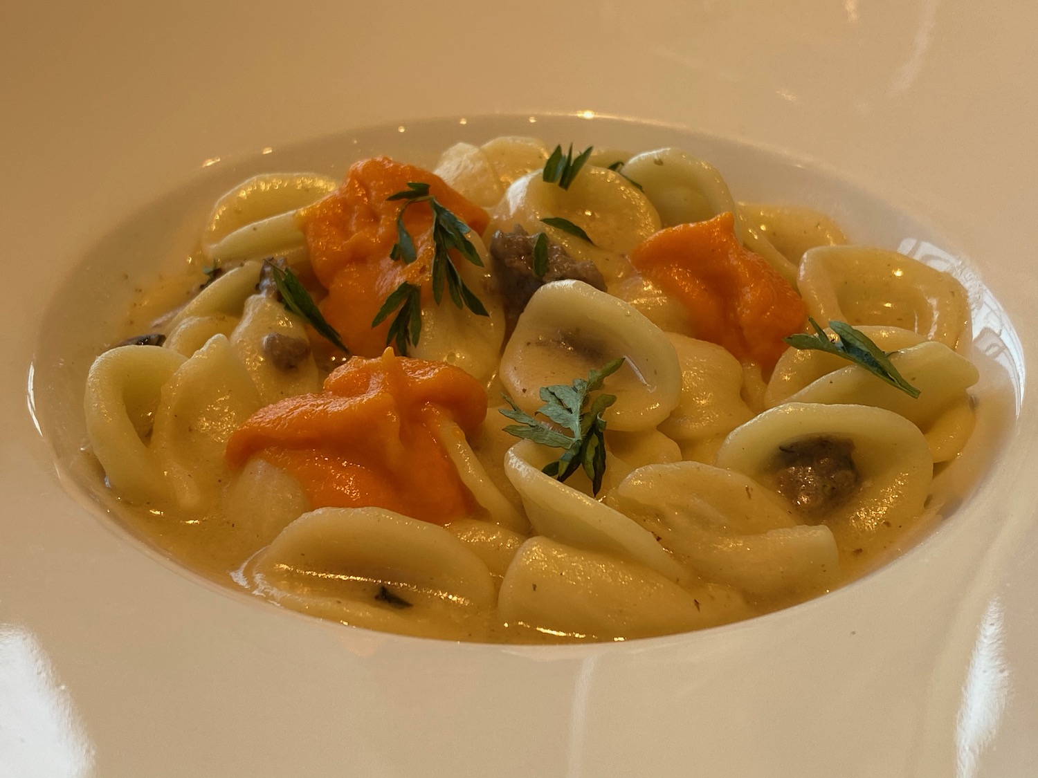 a bowl of pasta with sauce and herbs