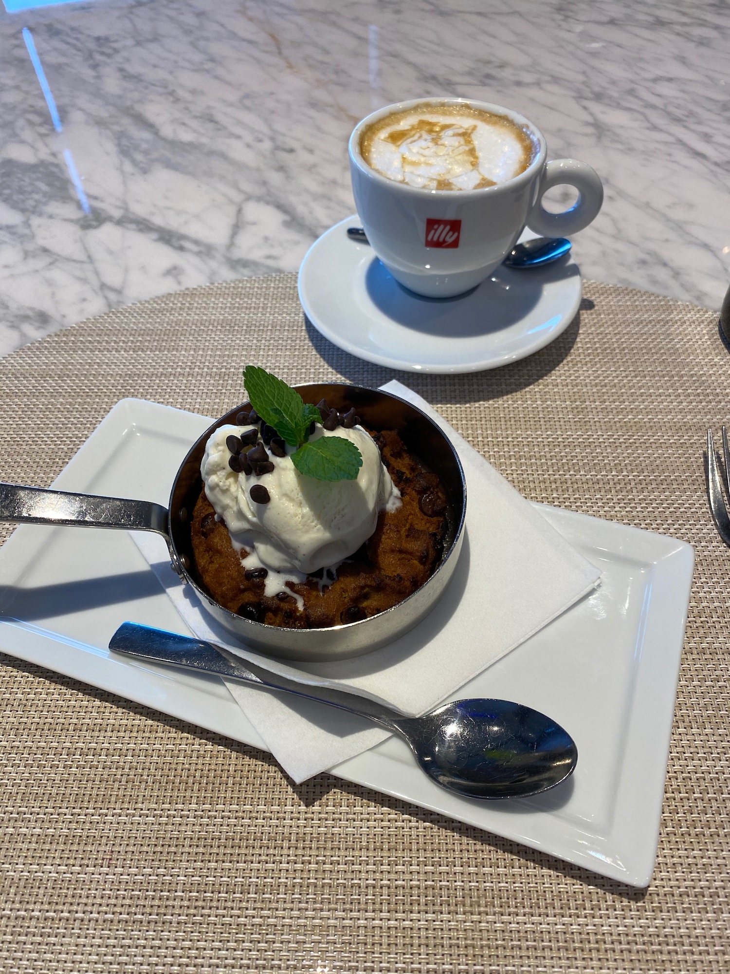 a dessert in a pan with ice cream and a cup of coffee