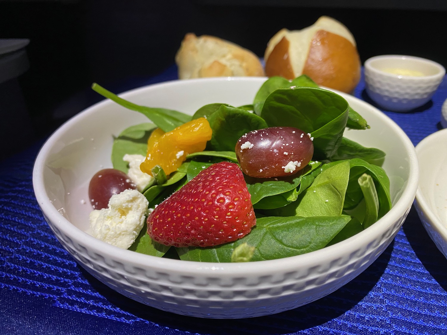 a bowl of salad with fruit and cheese