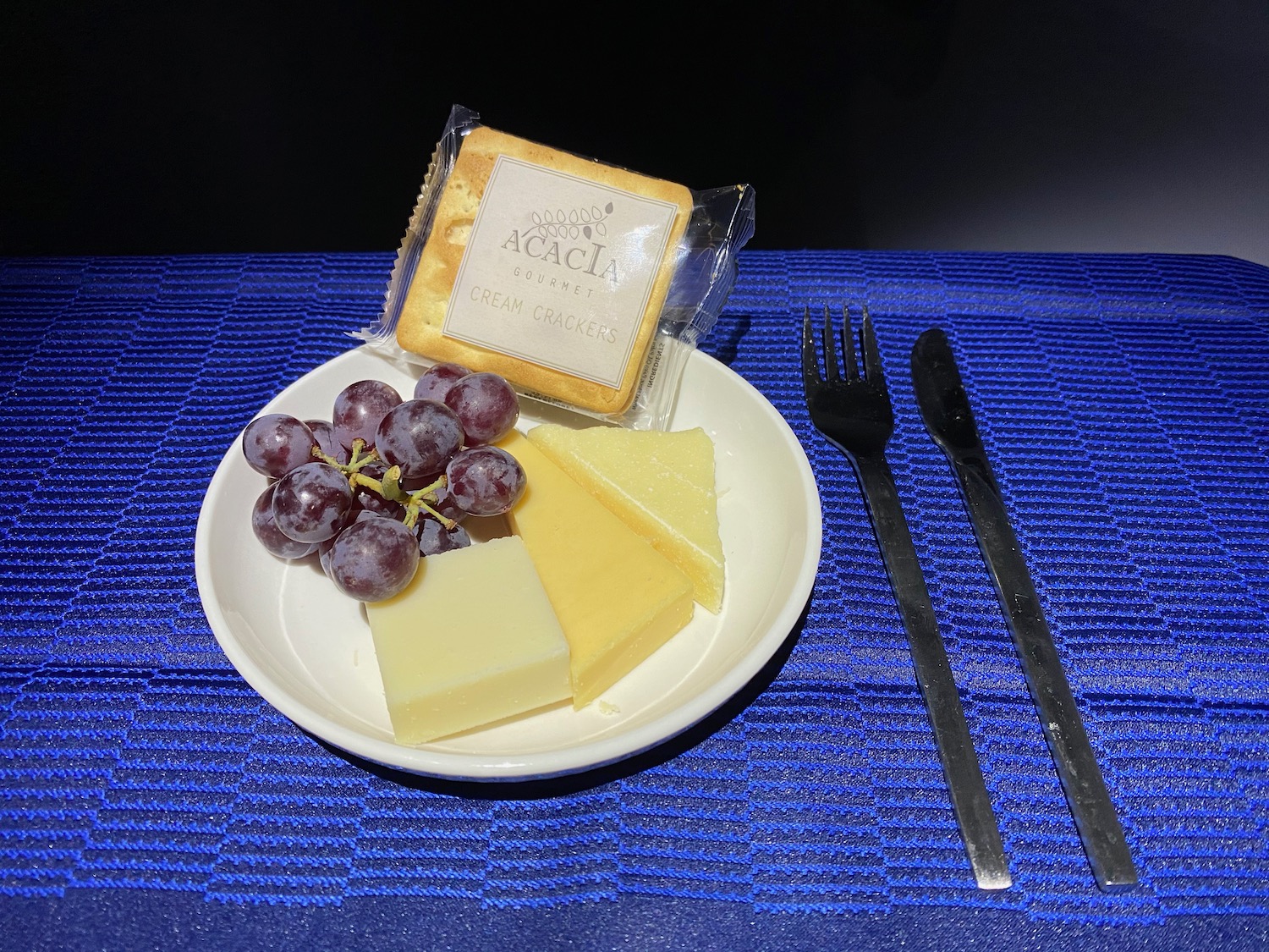 a plate of cheese grapes and crackers