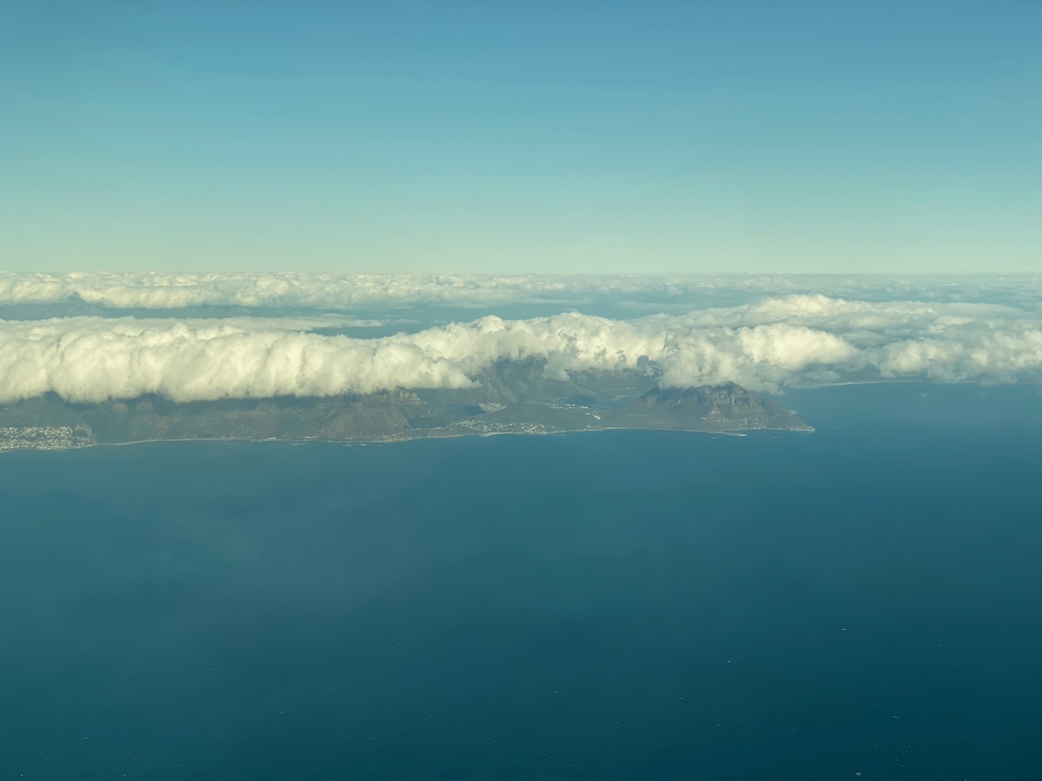 an island with clouds above it