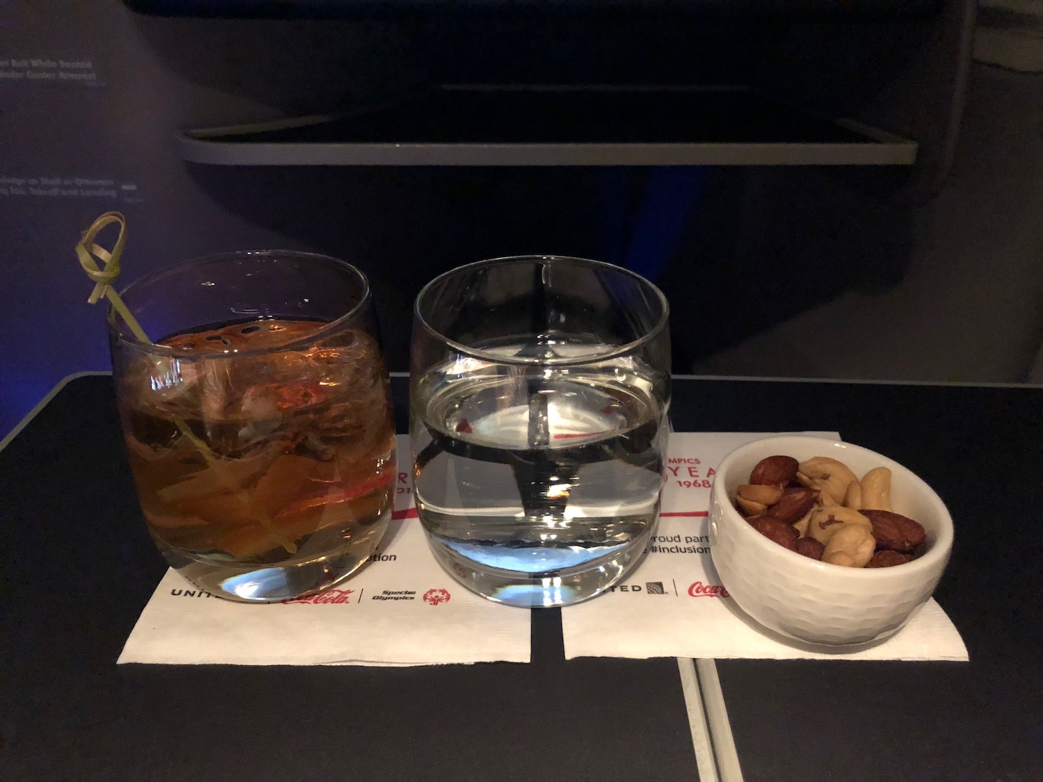 a glass of water and a bowl of nuts