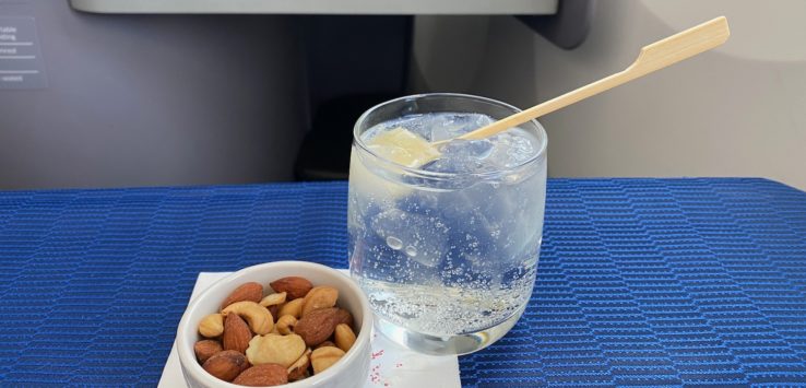 a bowl of nuts and a glass of water with a spoon