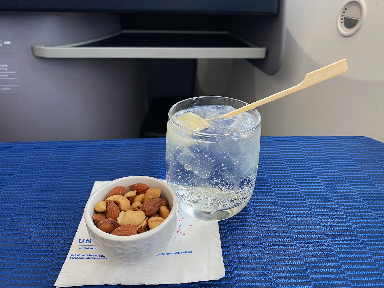 a bowl of nuts and a glass of water with a spoon