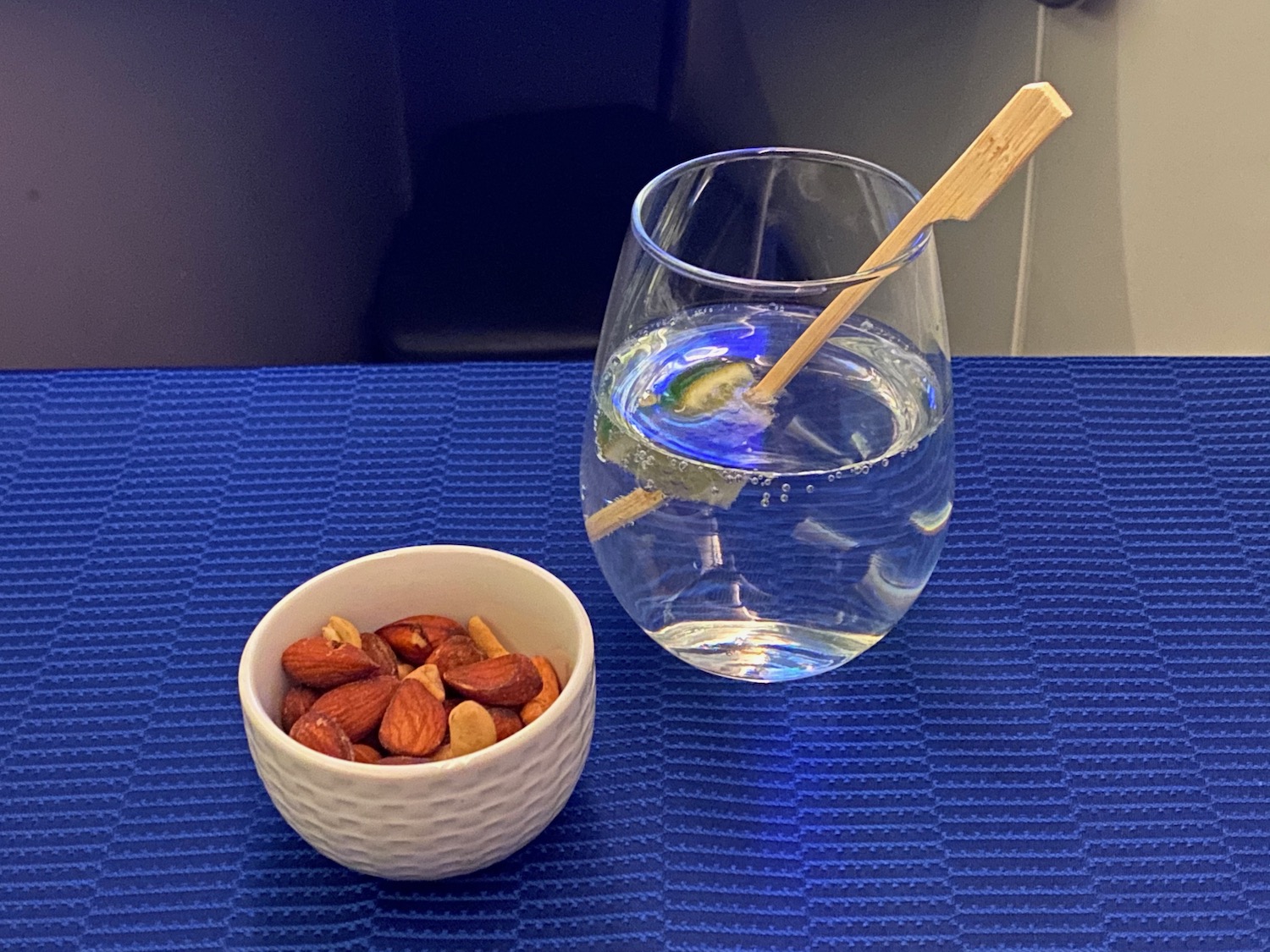 a glass of water and a bowl of nuts