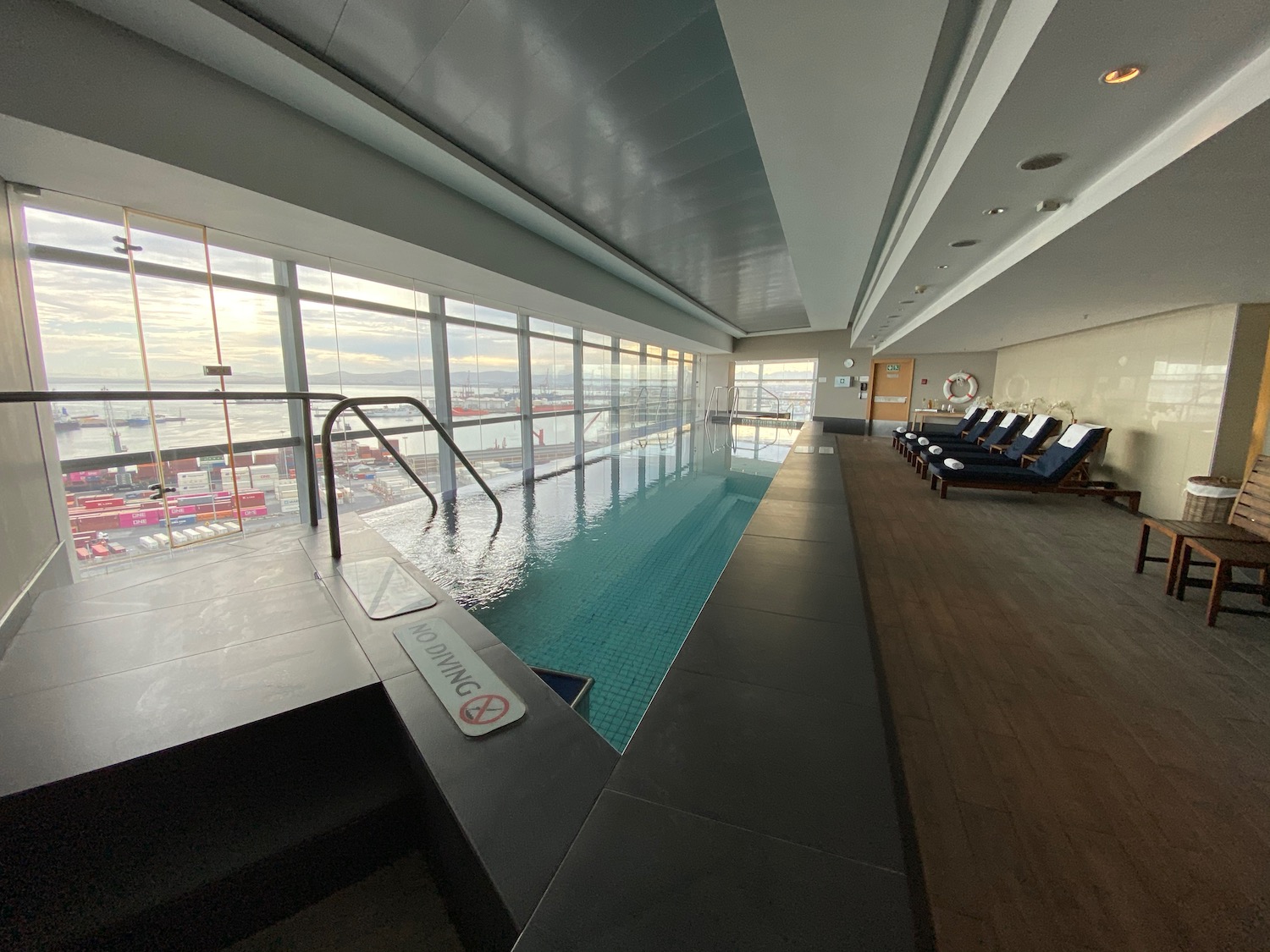 a pool with a large window and chairs