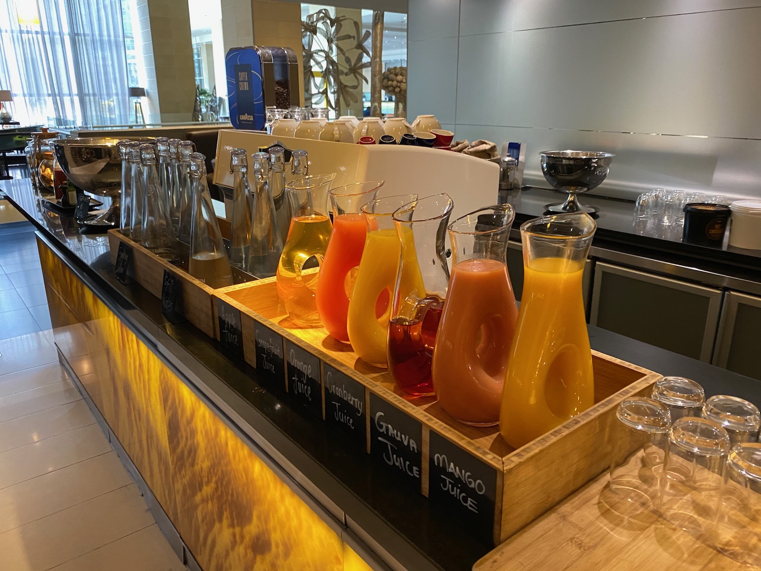 a row of glasses with different colored drinks in a wooden box