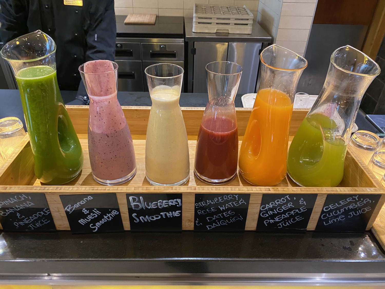 a row of different colored drinks in glasses
