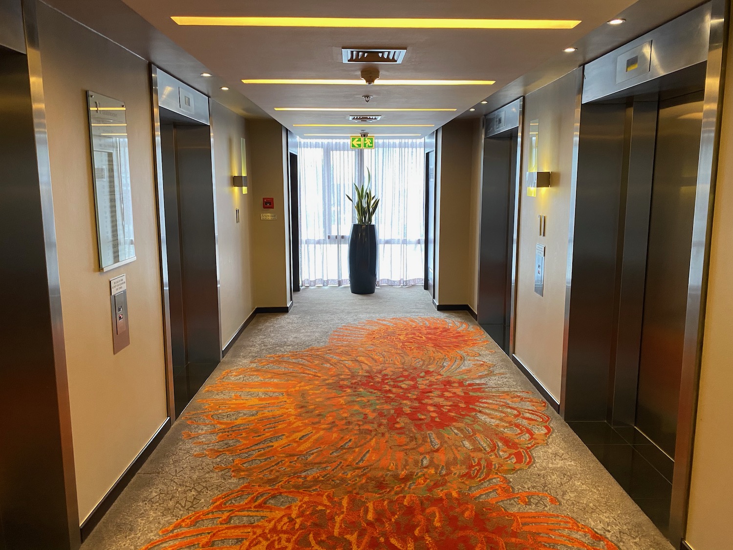 a hallway with elevator doors and a flower carpet