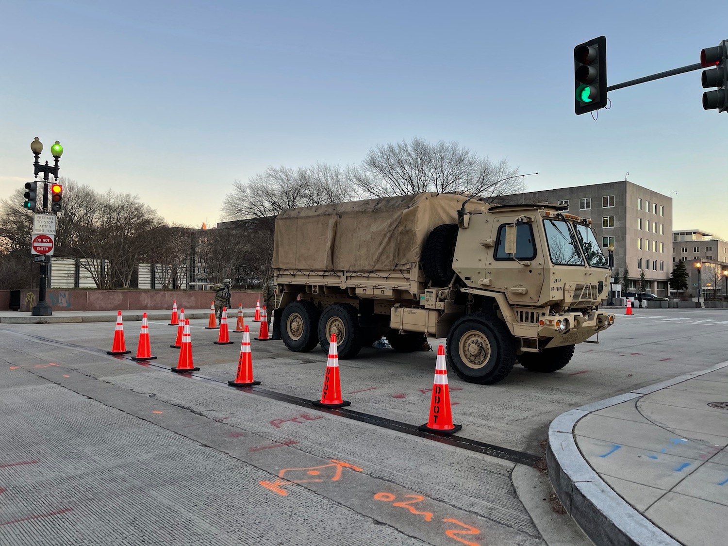 a military truck on a street with traffic cones