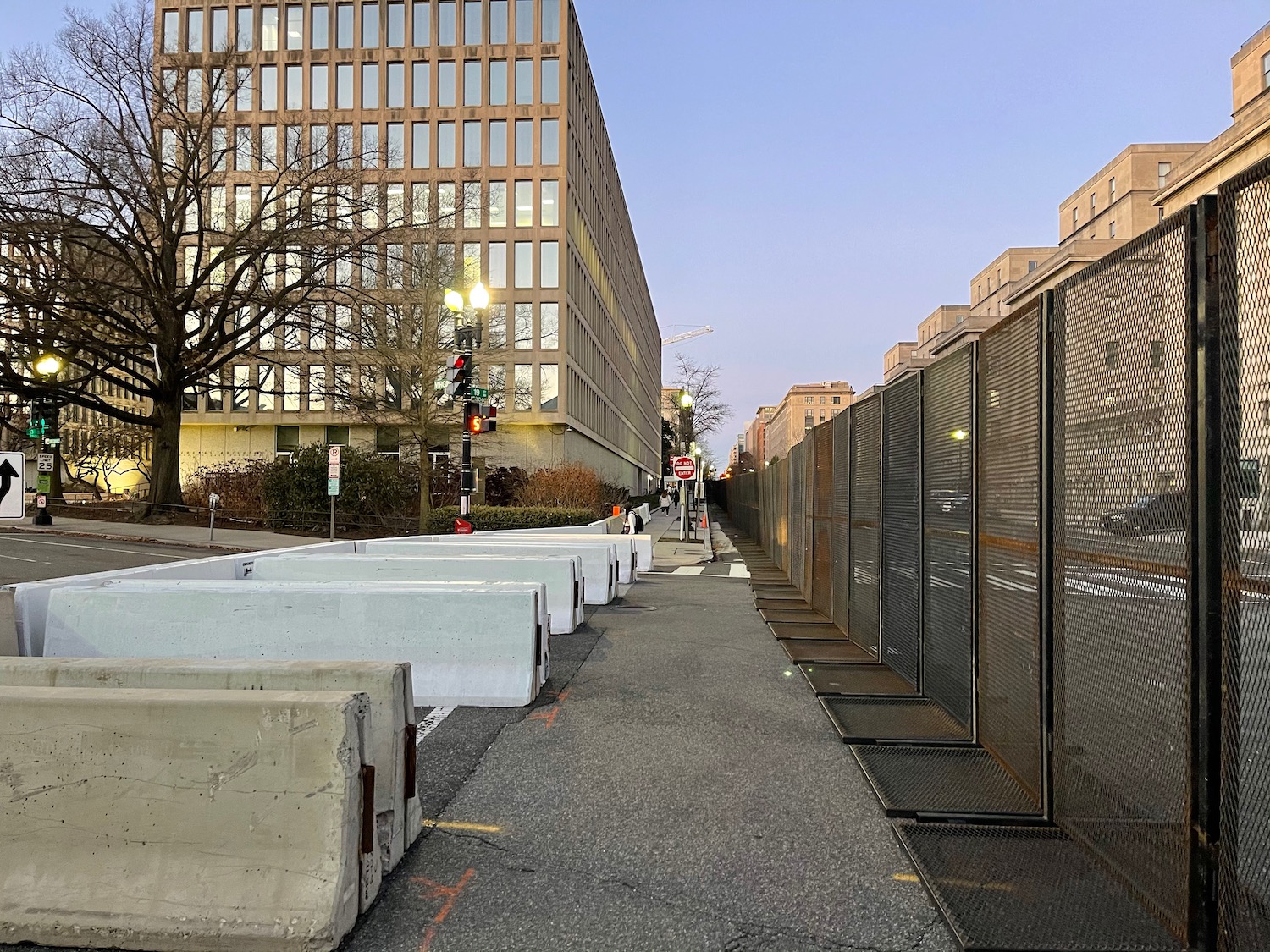 a sidewalk with concrete blocks and a fence