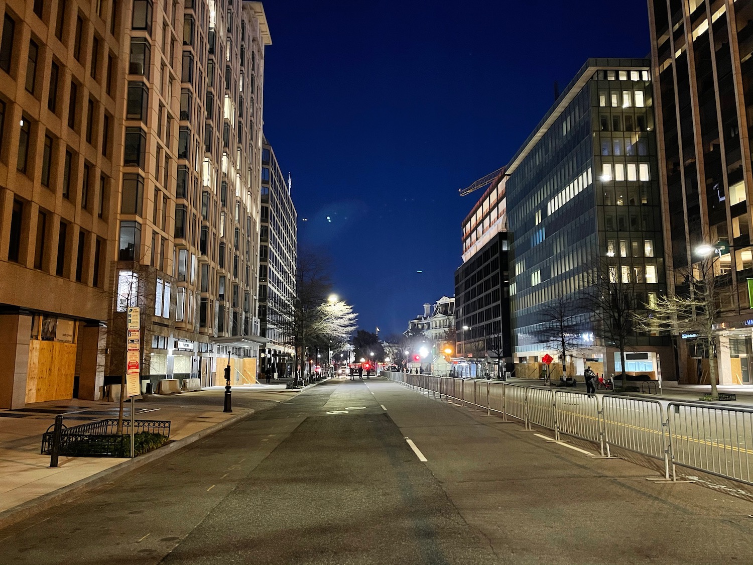 a street with buildings and trees at night