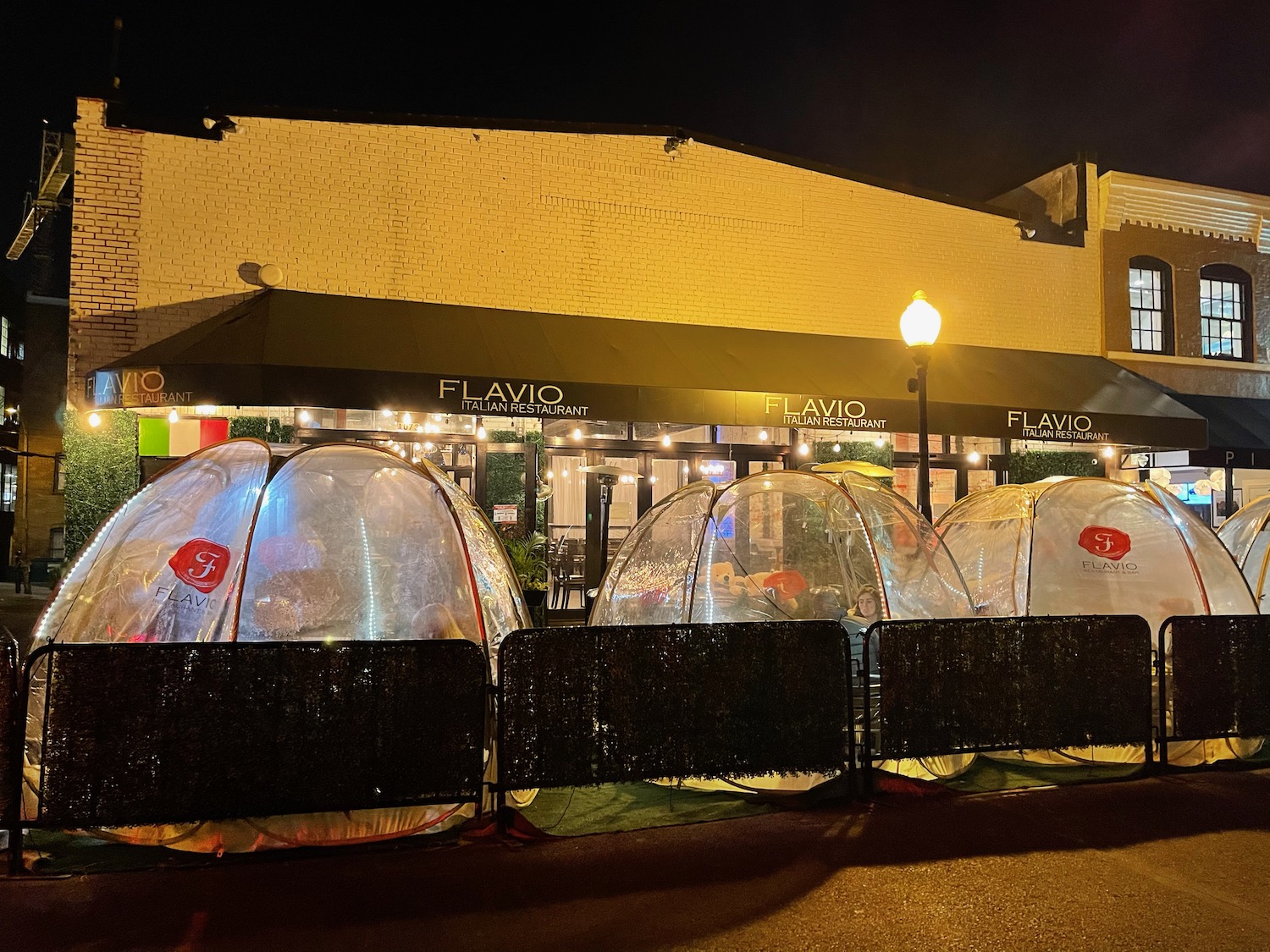 a row of transparent tents in front of a building